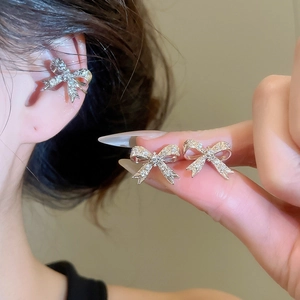 Dettaglio dell'orecchino a polsino a fiocco in argento con zirconi sull'orecchio