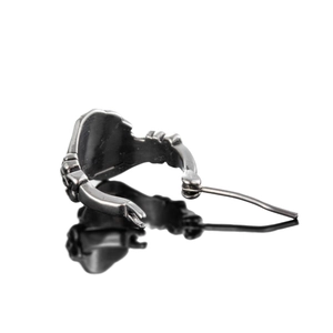Retro stainless steel skeleton hand earring in antique silver finish on a black mirror