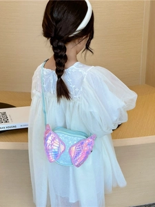 Cute children's blue crossbody bag with glitter wings worn with a white dress
