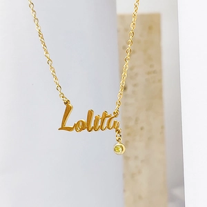 Close-up of gold Lolita name necklace with O-chain and a yellow birthstone pendant