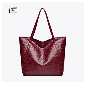 Detailed view of wine red crocodile pattern tote bag with polished texture and long handles
