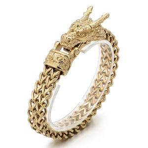 Gold stainless steel dragon head bracelet with thick braided chain on white background