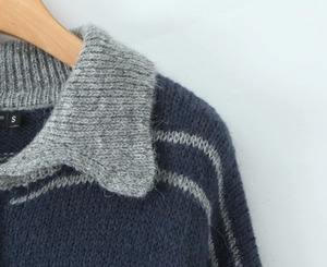 Detail of navy knit sweater showing polo collar, gray stripes, and fuzzy wool texture