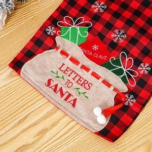 Detailopname van de kerstmanborduring op een rood geblokte kersttafelloper van stof
