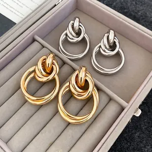 Boucles d'oreilles nœuds minimalistes en finitions or et argent polies dans un écrin