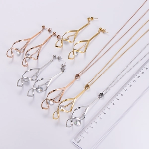 Three-color geometric spiral earring set with zirconia, shown with ruler for size scale