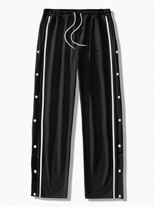 Detail of men's black joggers featuring white side stripes and functional snap-buttons