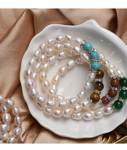 Top view of natural freshwater pearl bracelets with semi-precious stones on silk cloth