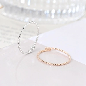 Detail of twisted and beaded titanium steel rings in silver and rose gold finishes