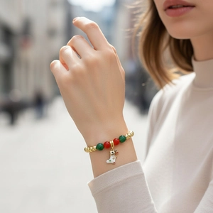 Detail of Christmas style bracelet with red green beads and a festive sock charm