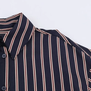 Detail of navy blue striped shirt with collar stitching and button craftsmanship