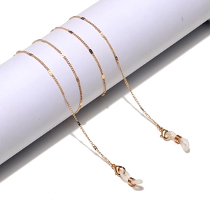 Detail of golden metal eyewear chain with lobster clasps and white silicone connectors