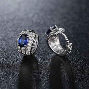 Silver hoop earrings with blue oval crystals and pave white zircon drop accents