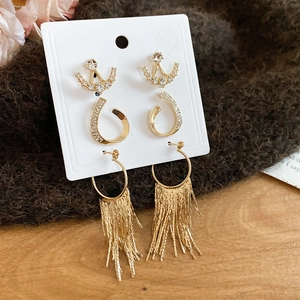Detailed view of three-piece gold earring set featuring rhinestones and metal tassels