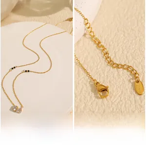 Detail view of gold stainless steel necklace with double teardrop zircon pendants and clasp