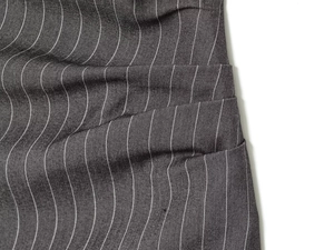 Macro shot of dark gray striped fabric showing fine textile texture and soft draping