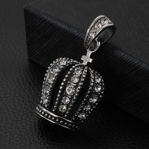 Macro shot of silver crown pendant with sparkling crystals on black leather background