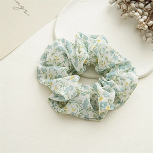 Detailed texture of floral scrunchie in light beige fabric with blue and yellow prints