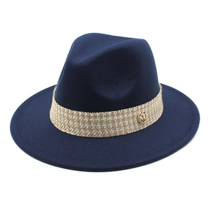Detail of dark blue wool fedora featuring woven band and gold M-letter metal buckle