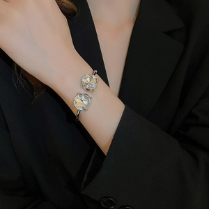 Detail view of a silver cuff bracelet featuring two large faceted sparkling clear crystals