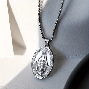 Macro detail of silver oval pendant with Virgin Mary engraving and French prayer text