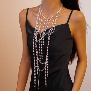 Macro view of multi-layer faux pearl fringe body chain with elegant draped beadwork