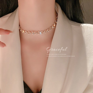 Vue détaillée du collier élégant plaqué or avec perles et strass brillants sur le cou