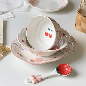 Detail of pink plaid ceramic plate with cherry and flower patterns for breakfast