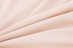 Detailed macro view of the pink knitted fabric texture and fine fiber weave for a women's dress