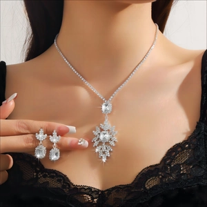Detailed macro view of luxurious silver snowflake pendant necklace and matching earrings set