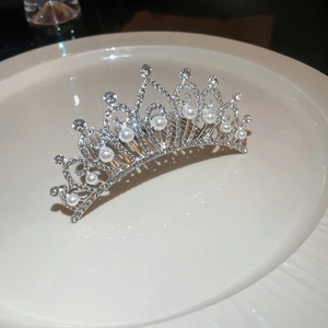 Détail du peigne à cheveux couronne argentée avec strass scintillants et perles élégantes
