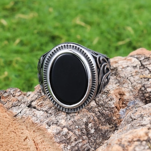 Vintage men's ring with black oval agate and ornate silver floral engraving on bark