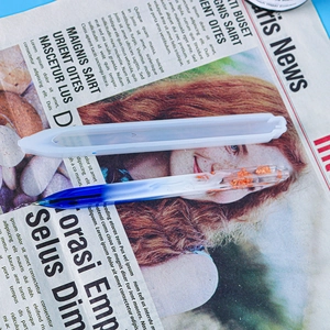 Detail of gradient blue resin pen with gold foil accents and translucent storage case