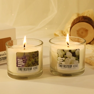 Two glass scented candles with wooden lids featuring lavender and jasmine in a cozy setting