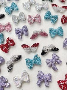 Close-up of sparkling rhinestone bow charms in various colors for DIY craft jewelry