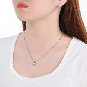 Silver stainless steel necklace and pearl earrings jewelry set worn by a female model