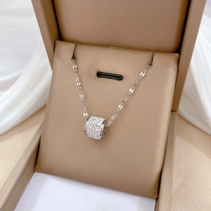 Sparkling silver titanium steel cylinder necklace with zircons on a white silk display