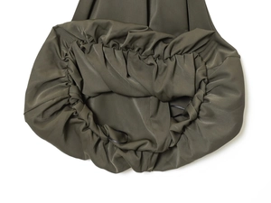 Close-up of olive green crop top featuring ruching details and silky fabric texture
