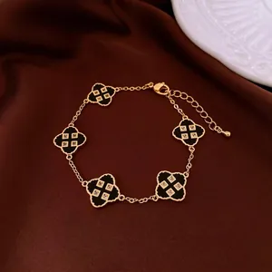 Elegant gold plated bracelet featuring five black clover pendants with zircon accents