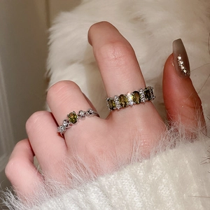 Close-up of vintage silver rings with olive green crystals on soft white fur