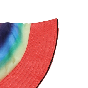 Macro shot of rainbow gradient knit bucket hat with red brim and black piping detail