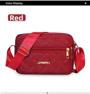 Close-up of red oxford fabric crossbody bag with heart quilting and gold zipper