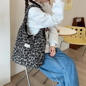 Chic leopard print faux shearling tote bag styled on model in a cozy cafe setting