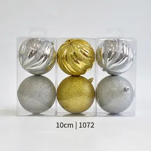 Detailed view of 10cm gold and silver Christmas balls with spiral texture in display boxes