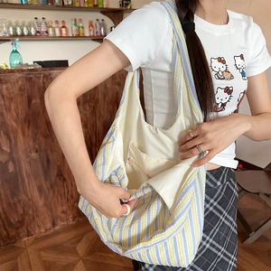 Detail view of large striped canvas tote bag showing interior lining and zipper pocket