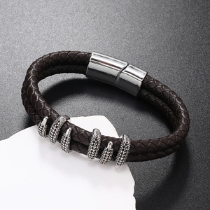 Detail of men's brown braided leather bracelet with silver claw beads and magnetic clasp