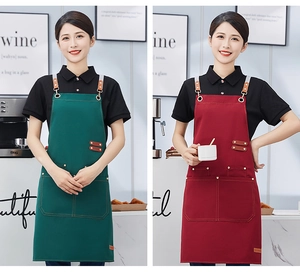 Commercial canvas apron in green and red with leather straps and multiple pockets