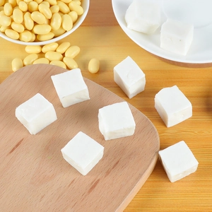Macro view of realistic tofu cubes with soybeans on a wooden board for dollhouse decor