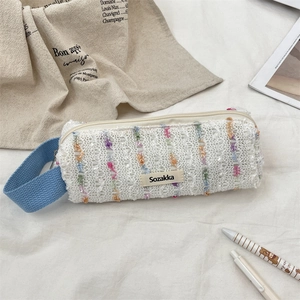 Detail shot of a floral lace pencil case with a blue handle and Sozakka brand label
