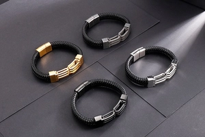 Dettaglio di quattro bracciali in pelle intrecciata con chiusure oro, argento, nero e grigio